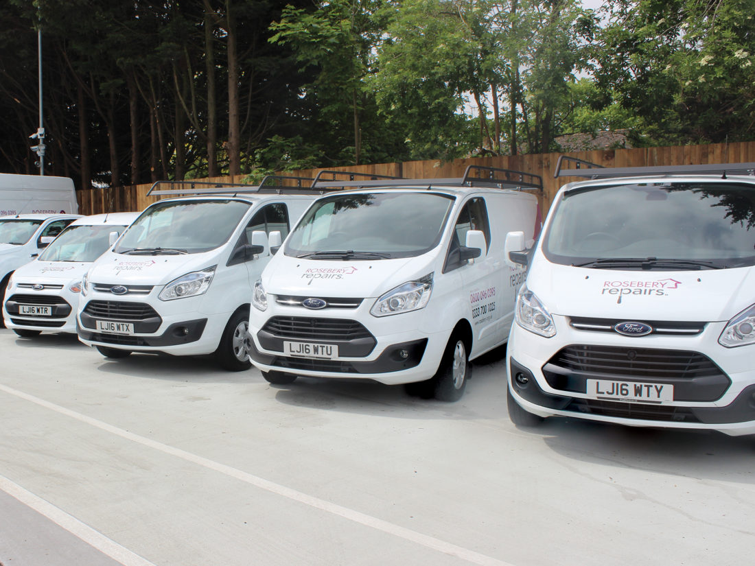 A line of large white vans with the Rosebery Repairs branding