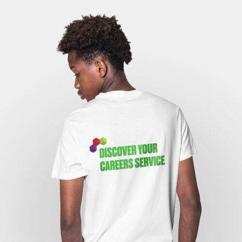 A young, Black male stands facing away from the camera. He wears a white t-shirt with the words 'Discover your careers service' on the back.